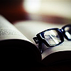 sarcastic_ink: A pair of glasses in the pages of a book. (glasses: in a book)