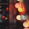chalcopyrite: Multi-coloured woven balls strung up with lights inside, reflected in a window (lights)