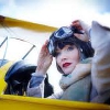 muccamukk: Phryne sitting in the cockpit of a biplane, about to pull her goggles down. (MFMM: Flying)