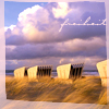 ninamalfoy: beach chairs surrounded by marram grass, big clouds in the background, upper right side: 'freiheit' (freiheit)