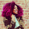 bilqis: black woman with a magenta afro smiling (stock: magenta hair)