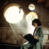 sbrackett: Ofelia from Pan's Labyrinth reading a book sitting on the edge of a tub with three circular windows behind her. (ofelia)