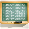 tallan: Writing board covered by the phrase: "I MUST OBSESS" (obsess)