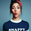 mlravenwrites: Head-and-shoulders shot of Stephanie Beatriz blowing a kiss at the camera, wearing a t-shirt that says "Snappy" (stephanie beatriz cute)