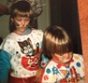 loleaudraws: Photograph lying on a table, small 5 year old girl with long brown hair wearing an 80's plastic Halloween cat costume and face paint, with a 4 year old boy with short brown hair wearing a similar clown costume (baby)