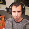 roadrunnertwice: Me looking up at the camera, wearing big headphones and a striped shirt. (Default)