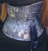 tshuma: Picture of a seated torso, wearing a short, dark dress, showing off the lines of a blue/silver brocade corset patterned with chrysanthemums. (corsetry)