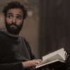 senmut: Yusef looking back over shoulder, book open in lap (TOG: Yusef)