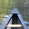 antimony: photo of the bow of a canoe in the water taken from inside the canoe. (canoeing)