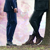 china_shop: A waist-down icon: a pair of legs slouching against a tree, feet in boots; another pair of legs, facing them, standing upright. Each pair has one knee bent towards the other. (Guardian - SW/ZYL legs)