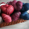 adrianners: Photograph of jewel-toned skeins of yarn in a basket (yarn)