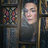 muccamukk: Moiraine looks down on village life, face framed by stained glass. (WoT: Moiraine Watches)
