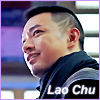 amedia: Close-up on face and left shoulder of man with buzzed hair, dressed in black, seen from slightly below and to the side. Caption: Lao Chu (Guardian: Chu 1)