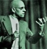 liriaen: a black and white photograph of Michel Foucault raising his hand (Michel says: obey the claw!)