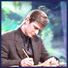 celli: Casey from Sports Night at the anchor desk, writing (Casey writing)