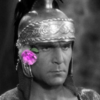 hoc_voluerunt: A black and white still of Henry Wilcoxon as Marc Antony in Cleopatra (1934). He wears a Roman helmet and looks very stern, but there's a flower in his ear, photoshopped to be bright pink. (Default)