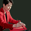 sakanawords: picture of a man in a red suit sitting at a desk and writing (zhuyilong-write-red)