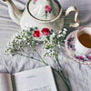 isabel_lunnen: a picture of a teapot, teacup with tea, and the top of a book (it is jane austen's "pride and prejudice") (tea (austen))