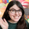 dessertgeek: A picture of me, a white woman with brown hair and glasses, smiling in front of a candy background (pic#16817726)