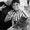 gloss: Two Palestinian boys flash the peace sign while holding their fluffy cat Lulu (Palestine)