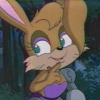 hexenprinzessin: An anthropomorphic rabbit girl in a forest. She has one robotic arm and is holding a finger of the other hand to her smiling mouth. (bunnie rabbot)