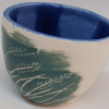 genarti: a handpainted cup made of white pottery, decorated with teal brushstrokes into which a design of wheat or grass has been carved in white ([art] playing with clay)