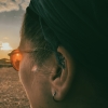 ludy: Close up of pink tinted “dyslexo-specs” with sunset light shining through them (Default)