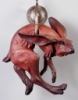 purplethebunny: A sculpture of a rabbit hanging from a large circular hook, looking awkwardly at the viewer (hanging)