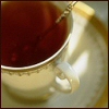 serpentine: a cup of tea on a saucer with a spoon in it (Food - Tea)