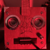 lambdaminer_edwin: Cigar box ukulele, looking strangely like a robot face, under a red light (robouke)