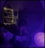 casx15: Photo of me in a circular mirror, holding my phone over my face, with purple lighting and a moon lamp in bottom right hand corner (profilepiccas)