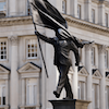 elisi: Man carrying flag which is blinding him and he steps off the plinth (Banksy statue)