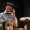 contrary_cal: A picture of Kleya Marki from Star Wars: Andor, standing at her workstation in the gallery backroom with her comms earpiece in, telling Luthen off. (Default)