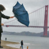 gumbie_cat: woman near the golden gate bridge with blown out umbrella (SF)