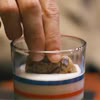 flourish: A chocolate chip cookie getting dipped in a glass of milk. (cookie)