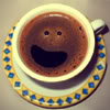 flourish: A cup of coffee with a smiley face made of foam. (cheers)