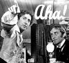 mizstorge: Black and white photo of Gene Wilder as Sigerson Holmes points at the viewer with  Marty Feldman playing his assistant Orville Sacker Marty Feldman from The Adventures of Sherlock Holmes' Smarter Brother. Text reads "Aha!" (Aha)