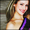 lannamichaels: An oversaturated picture of Tanith Belbin smiling while wearing a shoulder-less purple dress. (tanith)