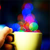 striped: Hand holding cup with multicoloured pixels/bubbles rising out of it (cup of light)