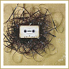 forthwritten: white cassette tape lying on tangled magnetic tape (tape)