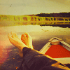 binz: a pair of feet rest up on the frame of a little rowboat that is floating on a still lake ([ stock ] life is but a dream)
