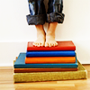 chalcopyrite: A stack of multicoloured books, with a barefoot someone tiptoe on top of them (happy feet)
