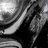 tripledigitride: A headlight in a rusty truck, in black and white. (black and white and chrome)