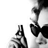 whiskeynkisses: extreme close-up of River in dark glasses with tiny gun (B&amp;W) (cake)