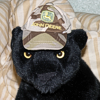 tornir: Photograph of a plushie leopard wearing a little John Deere baseball cap. (Mori)