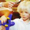lysergia: small frowning blonde boy playing with a toy airplane (come home)