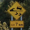 tea: A road sign that says your car may be knocked over by waves for the next 7km. (road sign)