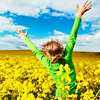 eillam: young girl in a field of yellow flowers, arms outstretched joyfully (joy!!)