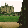 wake: Leaning against a stone wall, a castle in the background. (Guardsman)