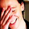 actiaslunaris: Tom Hiddleston - grinning, eyes shut, hand on his face (*facepalm*)